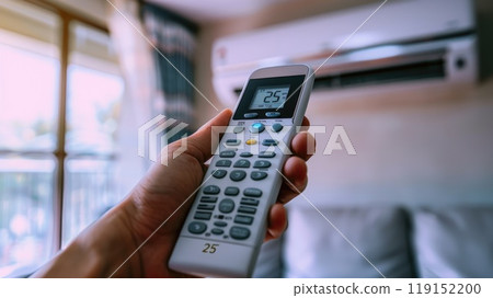 Hand holding air conditioner remote control to adjust the temperature to 25 degrees Celsius Hand holding air conditioner remote control to adjust the temperature to 25 degrees Celsius 119152200