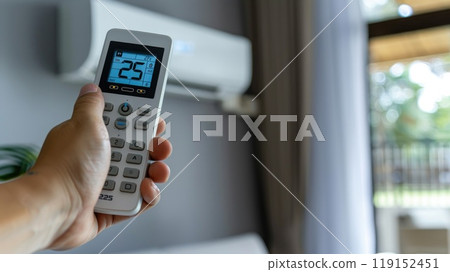 Hand holding air conditioner remote control to adjust the temperature to 25 degrees Celsius Hand holding air conditioner remote control to adjust the temperature to 25 degrees Celsius 119152451
