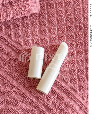 Opened lip balm stick on pink towels top view, lid mockup. Skincare beauty product 119153363