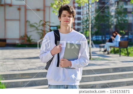 Outdoor portrait guy college student with backpack, laptop in hands 119153871