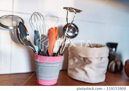 Kitchen utensils or cooking tools in iron decorative bucket, on kitchen wooden surface. Kitchen utensils collection Kitchen utensils or cooking tools in iron decorative bucket, on kitchen wooden surface. Kitchen utensils collection 119153909