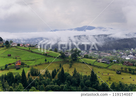Misty morning in Vorokhta village with scenic view of Carpathian hills and fog-covered mountains Misty morning in Vorokhta village with scenic view of Carpathian hills and fog-covered mountains 119154087