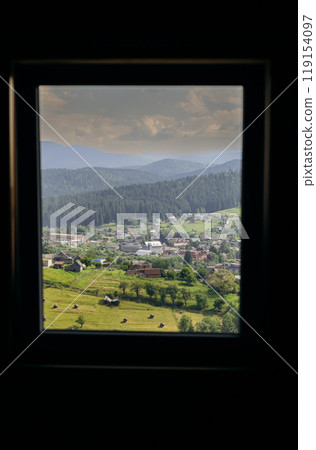 Vorokhta village view through window frame showcasing Carpathian mountains and green hills 119154097