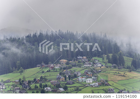 Misty morning in Vorokhta village with scenic view of Carpathian hills and fog-covered mountains 119154100