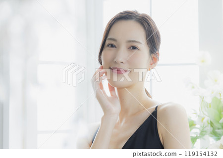 A woman in a black camisole dress standing by the window A woman in a black camisole dress standing by the window 119154132