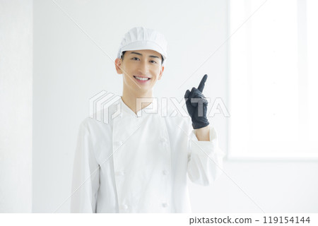 A young man wearing a chef's coat 119154144