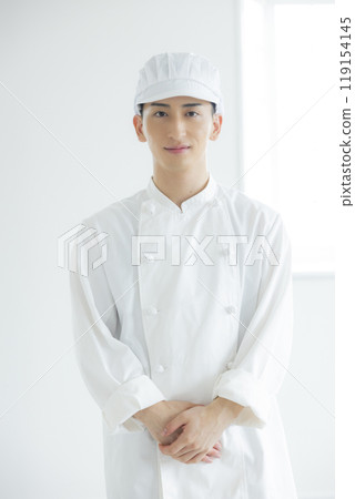 一個穿著廚師外套的年輕人 一個穿著廚師外套的年輕人 119154145