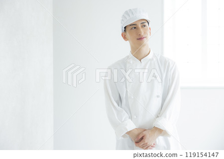 一個穿著廚師外套的年輕人 119154147