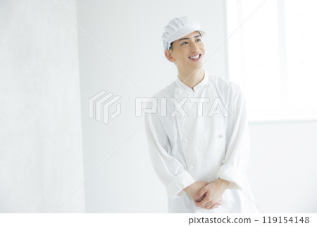 A young man wearing a chef's coat A young man wearing a chef's coat 119154148