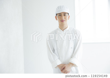 A young man wearing a chef's coat 119154149