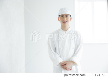 A young man wearing a chef's coat 119154150