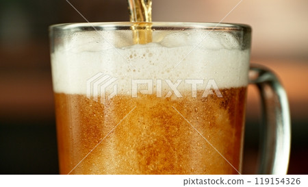 Close-up of beer pouring into pint , freeze motion. Close-up of beer pouring into pint , freeze motion. 119154326