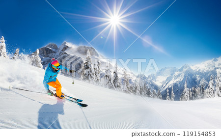 Man skier running downhill on sunny alpine slope 119154853