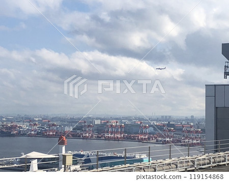 A plane flying overhead of the gantry cranes at Aomi Pier 119154868