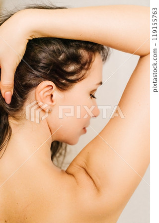 A woman with long hair is looking at the camera. She has a serious expression on her face. A woman with long hair is looking at the camera. She has a serious expression on her face. 119155763