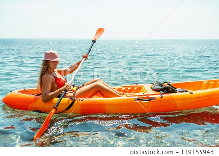 Kayak sea woman. Happy attractive woman with long hair in red swimsuit, swimming on kayak. Summer holiday vacation and travel concept. Kayak sea woman. Happy attractive woman with long hair in red swimsuit, swimming on kayak. Summer holiday vacation and travel concept. 119155943