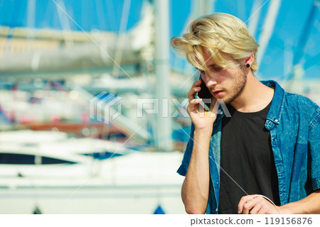 Blonde man talking on mobile phone Blonde man talking on mobile phone 119156876