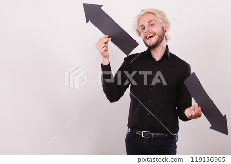 Man holding black arrows pointing left and right Man holding black arrows pointing left and right 119156905