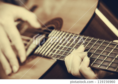 Closeup of man playing acoustic guitar 119156960