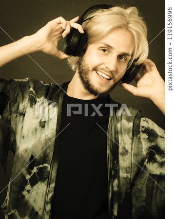 Blonde man singing in studio wearing headphones Blonde man singing in studio wearing headphones 119156998