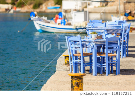 Open cafe outdoor restaurant in Greece on sea shore 119157251