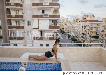 Experience an Elegant Yoga Practice on a Rooftop Pool while Enjoying a Stunning City View Experience an Elegant Yoga Practice on a Rooftop Pool while Enjoying a Stunning City View 119157498