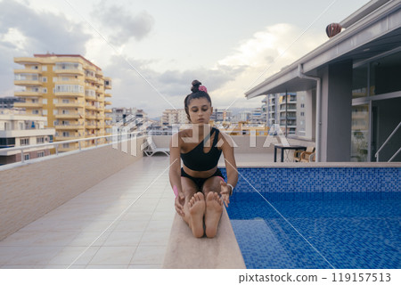 Engaging in Meditative Stretching by the Poolside Brings Serenity and Balance to Both Body and Mind Engaging in Meditative Stretching by the Poolside Brings Serenity and Balance to Both Body and Mind 119157513