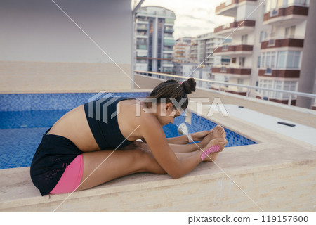 I am truly enjoying Yoga Stretching Sessions at a Beautiful and Modern Apartment Pool Setting 119157600