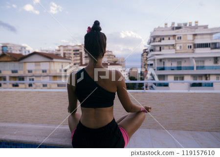 Engaging in Meditation by the Peaceful Pool while Enjoying a Beautiful City View Engaging in Meditation by the Peaceful Pool while Enjoying a Beautiful City View 119157610