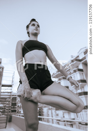 Experience the graceful yoga pose on a serene rooftop, embodying tranquility in motion 119157706