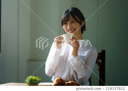 早晨,年輕女子在平靜的氣氛中喝一杯咖啡 早晨,年輕女子在平靜的氣氛中喝一杯咖啡 119157812