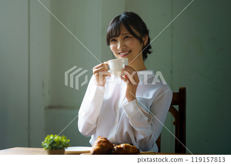 Young woman drinking a cup of coffee in a calm atmosphere in the morning Young woman drinking a cup of coffee in a calm atmosphere in the morning 119157813