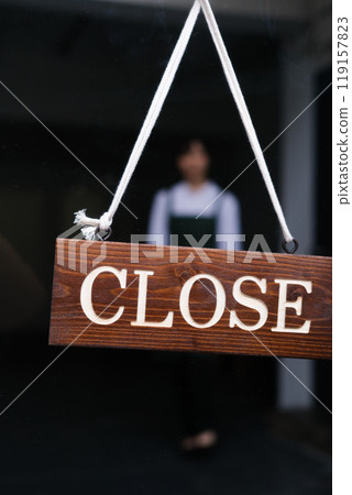 一位年輕的女店員翻開了一家咖啡館開幕時的招牌 119157823