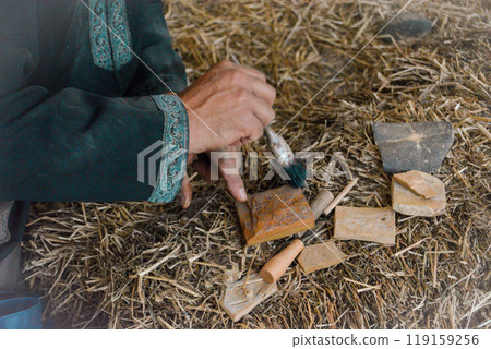 Hands of a master mason at a medieval festival in Portugal, working with stone using tools. Concept for reconstructing historical crafts 119159256