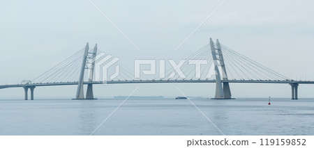 distant bridge over foggy bay on rainy day 119159852
