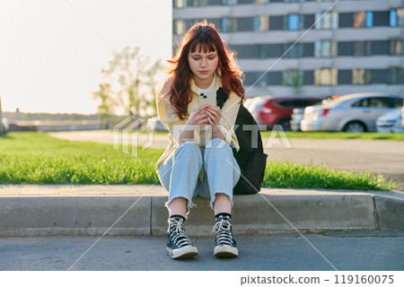 Young female college student with backpack using smartphone, outdoors Young female college student with backpack using smartphone, outdoors 119160075