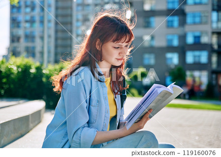 College student girl reading a book, outdoor 119160076