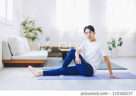 Man stretching in his living room at home Man stretching in his living room at home 119160257