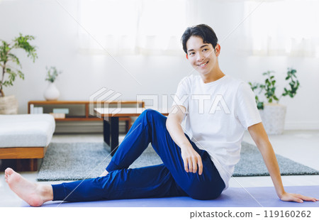 Man stretching in his living room at home Man stretching in his living room at home 119160262