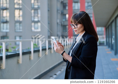 Mature business woman using smartphone, modern city background Mature business woman using smartphone, modern city background 119160266