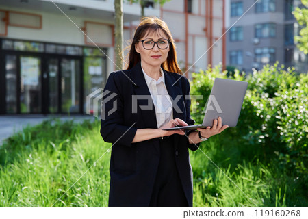 Portrait confident business successful mature woman, outdoors, urban background Portrait confident business successful mature woman, outdoors, urban background 119160268