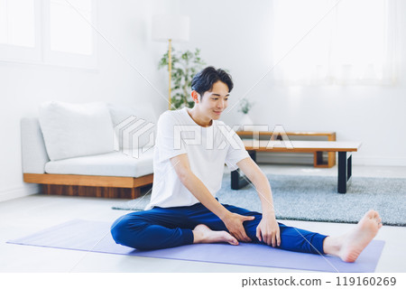 Man stretching in his living room at home 119160269