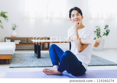 Man stretching in his living room at home 119160274