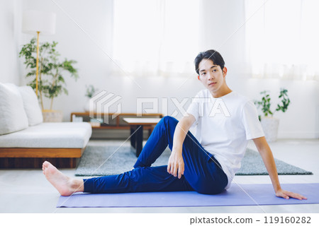 Man stretching in his living room at home 119160282