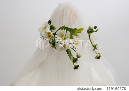 tulle fabric embroidery of flowers and birds on a veil On a thin fabric a woman embroiders straightening beautiful handwork on a mannequin wedding dress with bright decorations 119160378
