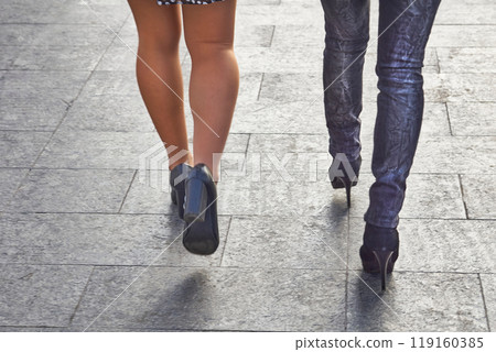 Women's legs in stockings and jeans. Easy walk along the pavement Women's legs in stockings and jeans. Easy walk along the pavement 119160385