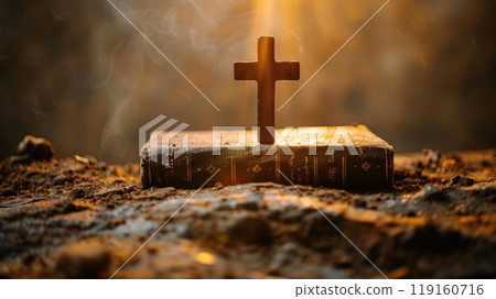A wooden cross is on top of a book 119160716