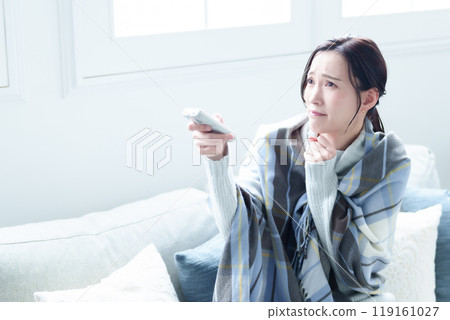 A woman who feels cold using an air conditioner A woman who feels cold using an air conditioner 119161027