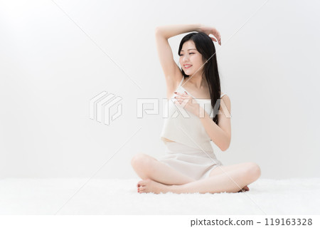美麗的年輕女子盤腿坐著，擔心她的腋窩除毛 119163328