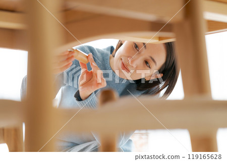 Woman repairing a table Woman repairing a table 119165628